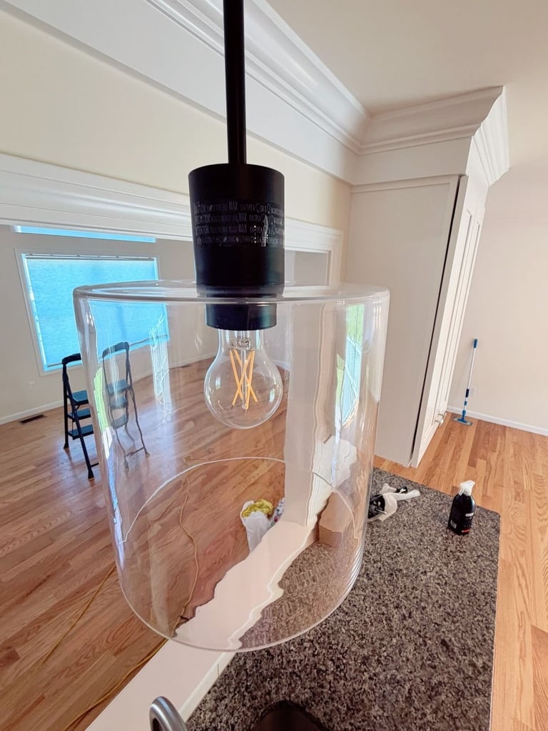 Modern pendant light with clear geometric shade and black stem in contemporary home interior with hardwood flooring