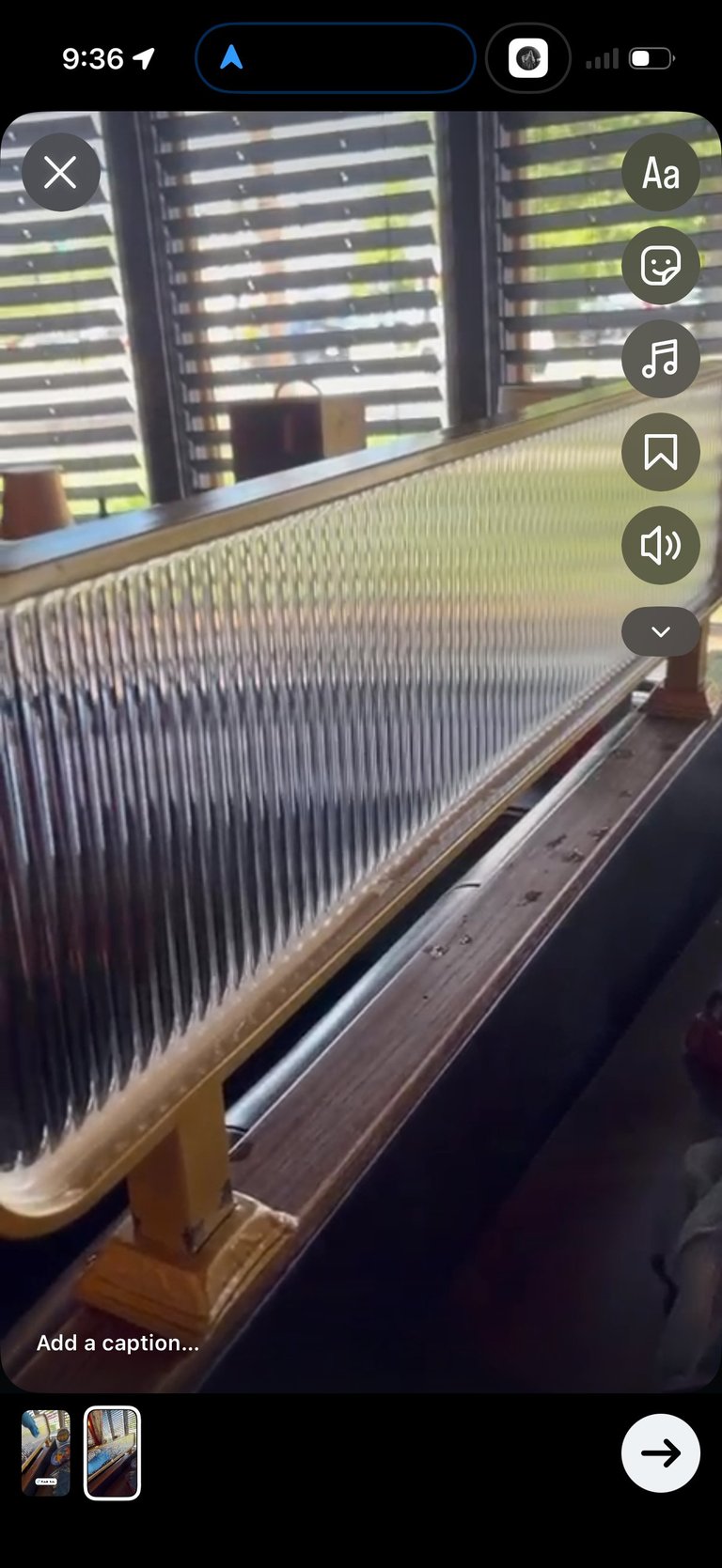 Close-up of piano strings inside a grand piano with wooden frame and urban building windows visible in background